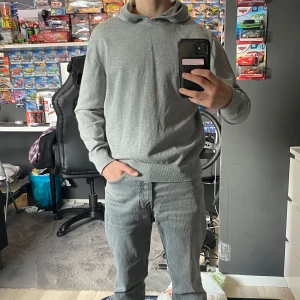 Grå hoodie från Grunt - Säljer en stilren grå hoodie från Grunt i storlek L i barn storlek. Perfekt för en avslappnad look med sin mjuka och bekväma passform. Huvan ger extra värme och stil. Passar utmärkt till vardags. Tröjan är Large i barn storlek Men passar 152-164