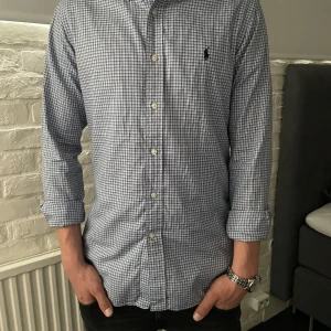 Ralph lauren skjorta L - Säljer en klassisk blårutig skjorta från Ralph Lauren i slim fit-modell. Skjortan har långa ärmar, knappar framtill och broderad logga på bröstet. Tillverkad i mjuk bomull och passar perfekt till en stilren look. Storlek L
