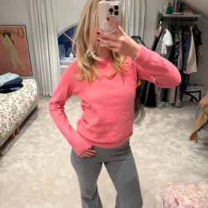 Rosa stickad tröja från Acne - Säljer en supermjuk och stilren rosa stickad tröja från Acne. Tröjan har rund halsringning och långa ärmar, perfekt för att liva upp garderoben med en färgklick. Passar lika bra till jeans som till kjol.