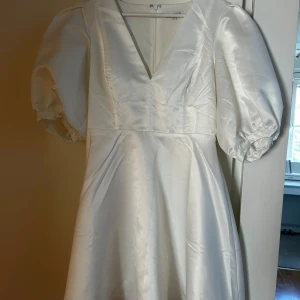 Vit långklänning med puffärm från Bubbleroom - Säljer en elegant vit klänning från Bubbleroom med v-ringning och puffärmar. Säker pga att jag hade den som ”back up” klänning till studenten men kom aldrig till användning 🙏🏽 Helt oanvänd med prislapp kvar.