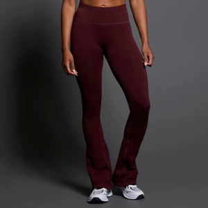 Vinröda ribbade bootcut leggings - Säljer ett par vinröda ribbade leggings med bootcut-modell. Byxorna är stretchiga och sitter tight upptill men släpper ut vid bensluten. Perfekta för en trendig och bekväm stil.