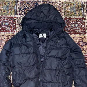 Calvin Klein Jacka - Den har liten skada vid ryggsidan men inget farligt går att sy