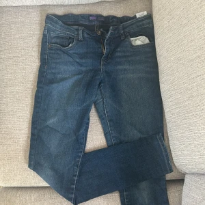 Levis Denim Legging jeans - Mörkblå jeansleggings från Levis med klassisk femficksdesign och lila sömmar i midjan. Byxorna har en slim passform och är tillverkade i stretchigt denimtyg för extra komfort. Perfekta för en avslappnad och snygg look.