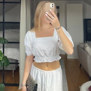 Blus - Säljer en söt vit croppad blus från NA-KD i storlek 34. Blusen har puffärmar, fyrkantig ringning och knytning i ryggen. Endast använd ett fåtal gånger. Perfekt till nu sommaren🌸☀️