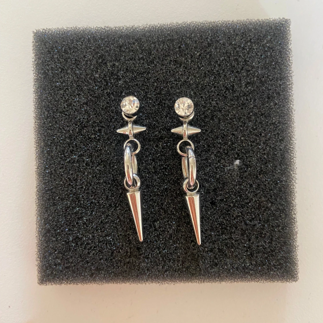 Silvriga örhängen med ring och spetsdetalj