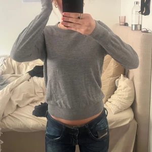 Grå stickad tröja från Filippa K - Säljer en klassisk grå stickad tröja från Filippa K. Passar till allt och är extremt lätt men ser ändå stilren ut, perfekt till tex kjol! Säljer då den ej är i min storlek!