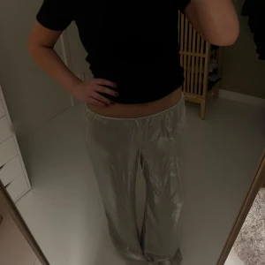 Silvriga vida satinbyxor - Säljer ett par silvriga vida byxor i satin med resår i midjan. Byxorna har en lös passform och faller snyggt längs benen. Perfekta för dig som gillar en trendig och bekväm stil. Aldrig använda, prislapp kvar!☺️