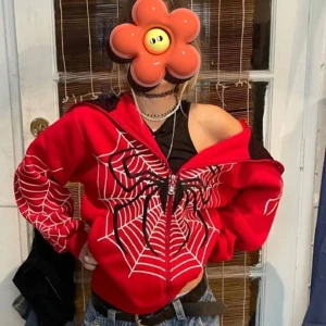 Röd spindeljacka med dragkedja - Säljer en röd jacka med svart och vitt spindelnätsmönster och stor spindel på bröstet. Jackan har dragkedja framtill och lång ärm. Perfekt för dig som vill sticka ut med en cool streetstyle.