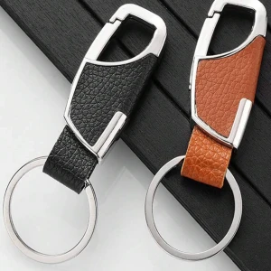 Nyckelringar i skinn och metall - Två stilrena nyckelringar med detaljer i silverfärgad metall och inslag av svart respektive brunt skinn. Modern design med struktur på lädret och robust metallring för nycklar.
