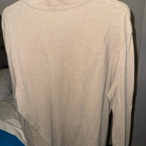 Beige långärmad pikétröja Polo Ralph Lauren - Säljer en stilren beige långärmad pikétröja från Polo Ralph Lauren. Tröjan har klassisk krage med två knappar och den ikoniska broderade loggan på bröstet. Tillverkad i mjuk bomull som är skön mot huden. Perfekt för dig som gillar en clean och tidlös look.