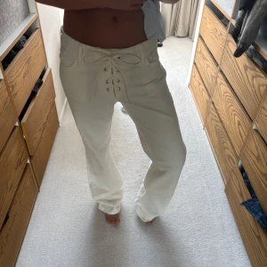 Vita jeans med snörning - Säljer ett par vita jeans med snygg snörning framtill i midjan. Byxorna har en bootcut passform och låg/medel midja. Helt nya och oanvända med lapp kvar från Zara