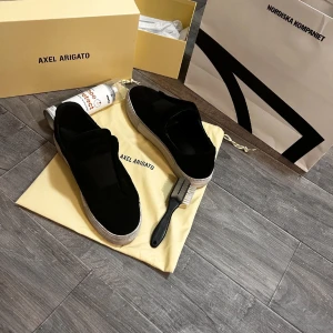 laceless 360 Axel Arigato - Stilrena svarta sneakers från Axel Arigato i mocka med vit platt sula. Mockaborste och Spray ingår. Svårt att hitta dessa då de inte säljs längre. Pris kan diskuteras och för frågor/bilder är det bara att kontakta😁