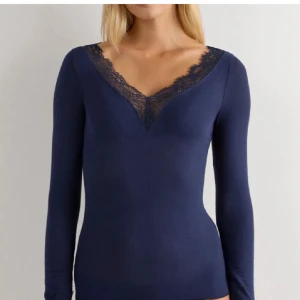 Intimissimi topp - Supersnygg mörkblå långärmad topp med v-ringning och spetsdetaljer. Nypris 489kr men säljer för ändast 150kr då den har ett litet hål på armbågen samt ett mycket litet hål på ryggen. 