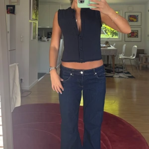 Mörkblå stickad ärmlös topp - mörkblå stickad topp med knappar framtill. Västaktig