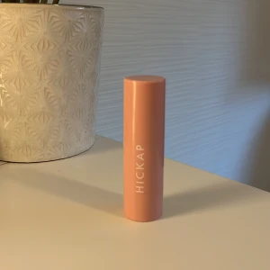 Hickap bronzer stick i icy chai - Bronzer stick från Hickap i en snygg brun ton. Kommer i ett stilrent, rosa hylsa med vit logga. Perfekt för att skulptera ansiktet och ge värme till din makeup. Enkel att applicera tack vare den smidiga stiftformen. På bild ser man hur mycket som finns kvar.