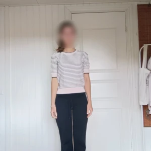 Randig stickad tröja från Bondelid XS - Supersöt stickad tröja från Bondelid i XS. Tröjan är ljusrosa och marinblå med randigt mönster, har korta ärmar och breda muddar i rosa. Perfekt till vår, sommar och höst för en skön och stilren look. Tröjan är 65% viskos och 35% polyester.