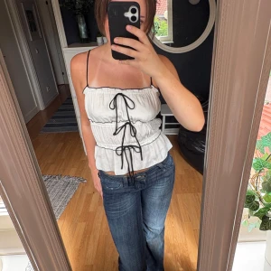 Supersöt vit rosett topp från Zara  - Suuuper söt vit topp med svarta rosetter. Rosetterna är justerbara så man kan efter preferens ändra storleken på rosetterna. Använd ca 2 gpngerr.