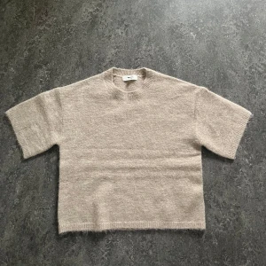 Beige stickad tröja från Gina Tricot - Kortärmad stickad tröja i beige från Gina Tricot. Har aldrig använt då jag inte tyckte färgen på tröjan passade mig och hade redan klippt av lappen så kunde inte lämna tillbaka 