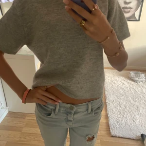 Grå stickad kortärmad topp - Helt ny. Aldrig använd.