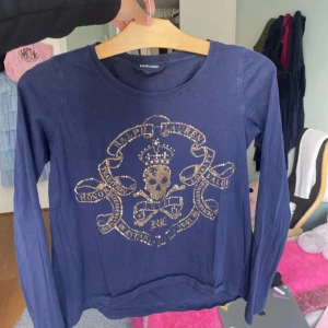 Mörkblå långärmad tröja Ralph Lauren - Snygg mörkblå långärmad tröja från Ralph Lauren med ett stort, glittrigt guldtryck. Passar XS
