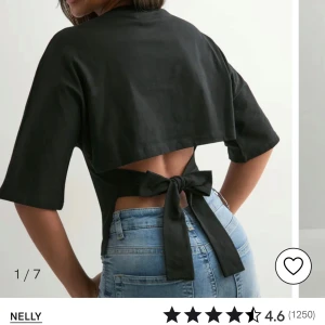 Svart topp med öppen rygg från Nelly - Svart topp från Nelly med halvlånga ärmar och en snygg öppen rygg som knyts. Eftersom man knyter så kan man bestämma hur tight den ska sitta, den är i storlek L men passar s/m också beroende på hur man väljer att knyta den. Helt oanvänd 