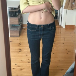 Mörkblå bootcut jeans - Snygga mörkblå bootcut jeans med låg midja. Perfekta för en avslappnad stil. Klassisk design med fem fickor och knappgylf.