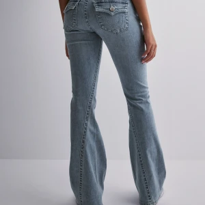 Blå bootcut jeans - True Religion bootcut jeans i den populära modellen Joey Flare. Säljer för att de är för stora i midjan, de har midjemått 40 och är stretchiga. Storlek 29.  De är även uppsydda till att passa någon som är runt 160-162. Men detta kan sprättas upp så de passar någon runt 165. Fråga gärna om ni har funderingar!