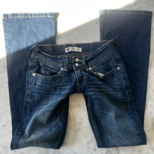 Lowwaist bootcut jeans - Skitsnygga lowwaist jeans i mörkblått. Har ett snyggt hål på knät. Innerbenslängd 76 cm, midjemått 64 cm. Tyvärr är de för små för mig därav ingen bild på 🫶🏼