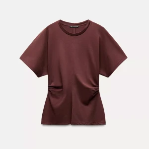 T-shirt från Zara - Säljer en brun/röd t-shirt från Zara med korta ärmar, rund hals och markering i sidan. Tröjan har knappt används och är i nyskick. 