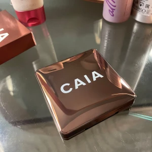 Bronzer från CAIA - Snygg bronzer från CAIA i nyansen La Digue. Kommer i en elegant brun förpackning med spegel. Perfekt för att ge ansiktet en solkysst look.