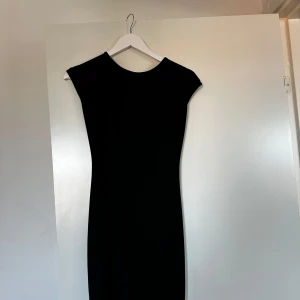 Svart klänning med öppen rygg - Superfin, ärmlös klänning med lite öppen rygg och knydetalj. Jag är 167 cm lång, och på mig räcker den ner till strax över knäna. 🖤