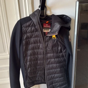 Svart jacka från Parajumpers - Snygg svart jacka från Parajumpers med quiltade detaljer och dragkedja. Jackan har en huva och ett märke på ärmen. Säljder denna för användes inte. (Använt 3 gånger) Köpt för 4049kr. Pris kan diskuteras vid snabb affär.