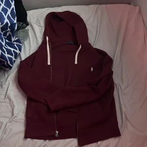 Vinröd zip från Ralph Lauren - Säljer en snygg vinröd hoodie från Ralph Lauren. Används inte så ofta eftersom den är 1 storlek för liten för mig själv. Svår att få tag på