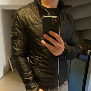 Svart jacka från Snoot - Säljer en svart jacka från Snoot med dragkedja framtill. Jackan har en stilren design och är perfekt nu till våren! 