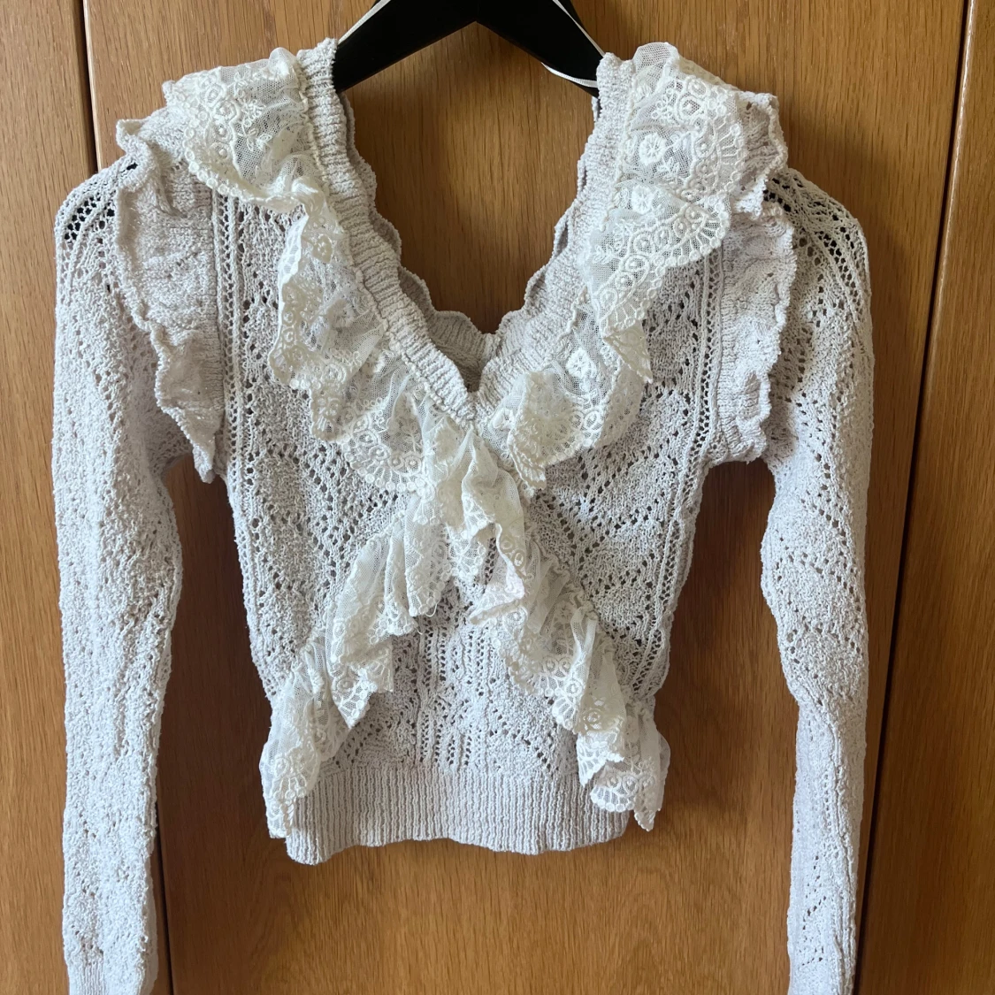 Vit stickad tröja med volangdetaljer