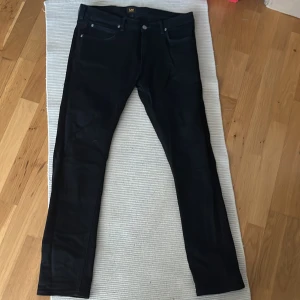 Svarta jeans från Lee - Snygga svarta jeans från Lee i modellen Luke. De har en klassisk femficksdesign och en smal passform som ger en stilren look. Perfekta för en modern och avslappnad stil.