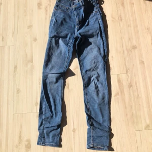 Blå jeansbyxor - Snygga blå jeansbyxor med klassisk design. De har en normal passform och är perfekta för en avslappnad stil. Byxorna har en dragkedja och knappar framtill.