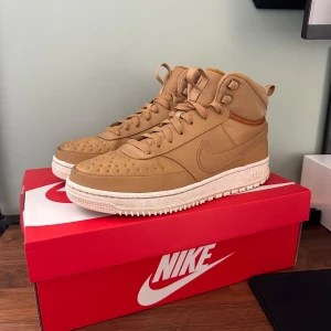 Nike sneakers - Snygga beige sneakers från Nike med snörning och vattentät. Perfekta för en stilren look.