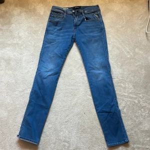 Blå slim fit jeans - Säljer ett par blå slim fit jeans med klassisk femficksdesign och dragkedja. Jeansen har en smal passform och normal midja, perfekta för en stilren vardagslook. Materialet är mjukt och stretchigt för extra komfort. Är ca 188 lång