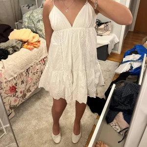 Vit ärmlös klänning med broderade detaljer - Säljer en söt vit kortklänning med broderade detaljer från Zara. Klänningen är ärmlös med smala axelband och har en v-ringad urringning. bortklippt lapp men tror stil S! går att knyta i ryggen. öppen för byten och pris går att diskutera!❤️