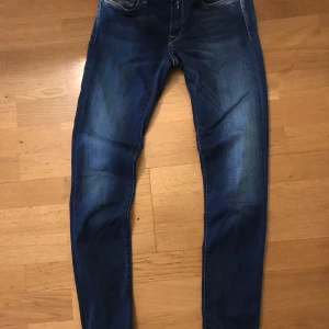 Replay  skinny jeans storlek 25 - Säljer ett par mörkblå skinny jeans med klassisk huperflex  och lätt slitning framtill. Jeansen har normal passform upptill och smalnar av längs benen. Perfekta för en avslappnad och stilren look.