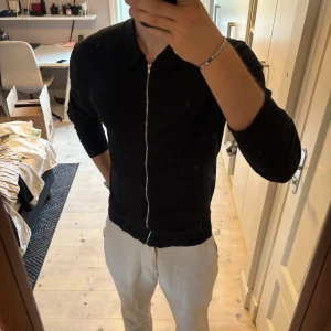 Svart ziptröja med krage - Säljer en svart tröja med hel dragkedja framtill och klassisk krage. Tröjan har lång ärm och en stilren, enkel design som passar till många olika outfits. Materialet känns mjukt och smidigt, perfekt för en clean look. Nypris 999kr bra skick och passar storlek s