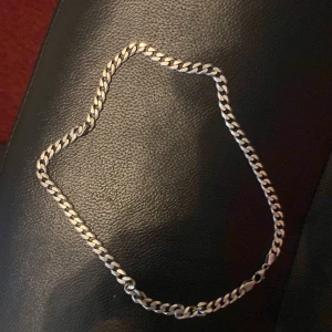 Silverfärgat kedjehalsband i äkta silver - Säljer ett stilrent halsband i silver med klassisk pansarlänk. Halsbandet är märkt med 925 vilket betyder att det är tillverkat i äkta sterlingsilver. Perfekt accessoar för dig som gillar tidlös och enkel design.