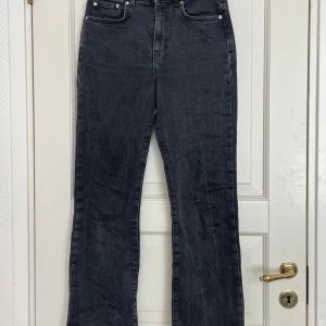Svarta bootcut jeans - Säljer ett par svarta bootcut jeans med klassisk femficksdesign och hög midja. Jeansen har raka ben med lätt utsvängning nertill och stängs med dragkedja och knapp. Perfekta till vardags för en stilren look.