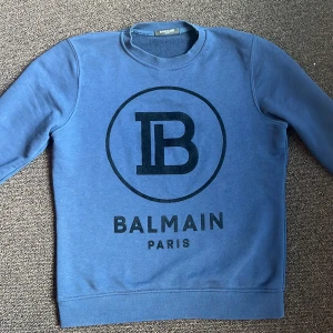Blå Balmain Paris tröja - Säljer en fet Balmain tröja för 2500.  I strlk M. Köpt för 6500 i Dubai. Perfekt skick nästan inte alls använd. Pris kan diskuteras vid snabb affär. Skickar den direkt.