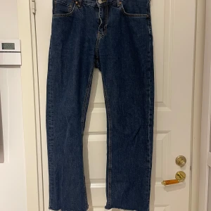 Blå jeans med låg midja och raka ben - Lågmidjade jeans med waist 31 och length 32. Dem är dock avklippta så dem är kortare i benen!