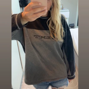 Grå och svart sweatshirt från NEXT - Säljer en grå och svart sweatshirt från NEXT med broderad logga på bröstet. Tröjan har lång ärm och rund halsringning. 