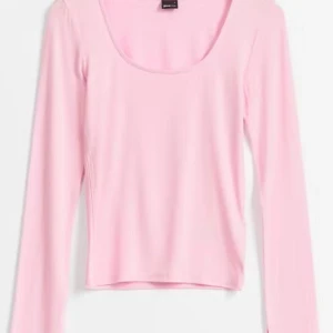 Ljusrosa långärmad topp från Gina Tricot - Säljer en ljusrosa långärmad topp från Gina Tricot. Toppen har en rundad urringning och är tillverkad i ett mjukt, stretchigt material som sitter snyggt på kroppen. Perfekt att styla med jeans eller kjol. Jag har använt tröjan väldigt få gånger och den har inget tecken på användning förutom att prislappen är borttagen. Ordinarie pris för tröjan var 200 kronor.
