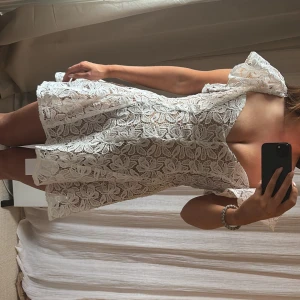 Studentklänning  - Superfin vit kortklänning i spets med blommigt mönster och volangdetaljer vid axlarna. Perfekt till student! Köpt från miss rosier storlek S