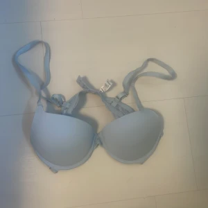 Ljusblå bandeau tubtopp - Snygg ljusblå bandeau tubtopp med vadderade kupor och justerbara axelband. Perfekt för att bära under en skjorta eller som den är till jeans eller kjol. Enkel och stilren design som passar till många outfits.